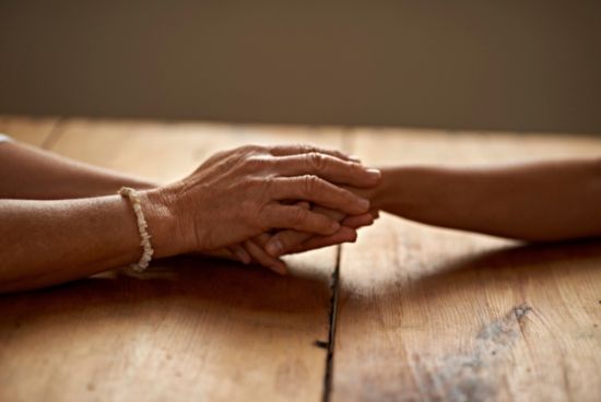 People holding hands on wooden table